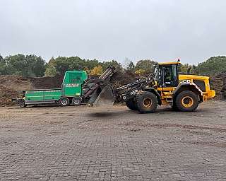 Baugeräte im Einsatz Ein Bagger und ein Anhänger auf einem Baustellengelände.
